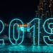 Bright neon '2019' sign with Christmas tree, perfect for New Year's festivities.